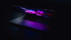 Partially open laptop with dramatic graphics glowing from the screen.