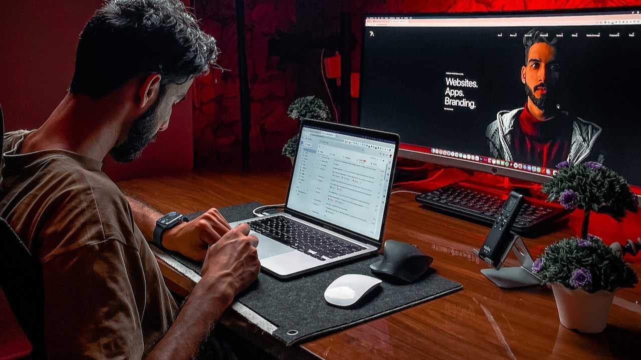 website design1-rubaitul-azad Man working on laptop in home-office setting.