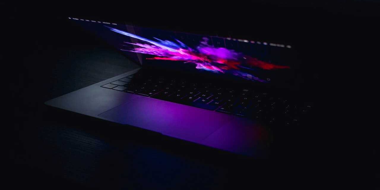 Partially open laptop with dramatic graphics glowing from the screen.